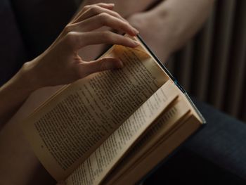 Cropped hand of woman reading book