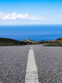 Surface level of road by sea against sky