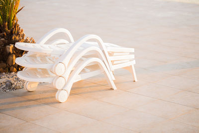 Close-up of empty deck chairs on tiled floor