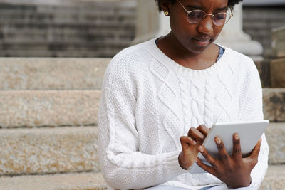 Midsection of woman using digital tablet outdoors