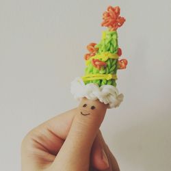 Close-up of hand holding flower over white background