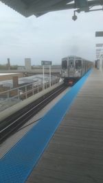 Train at railroad station platform against sky