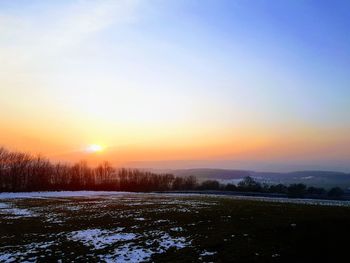 Scenic view of snow field against sky during sunset