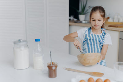 Smiling girl preparing food at home