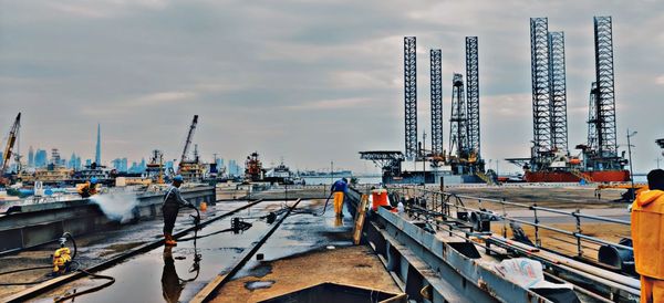 Cranes at construction site against sky