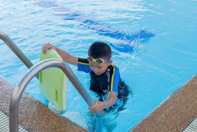 Boy with inflatable in swimming pool