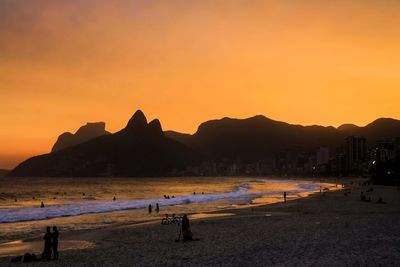 Scenic view of beach against clear sky during sunset