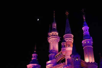 Low angle view of illuminated buildings against sky at night