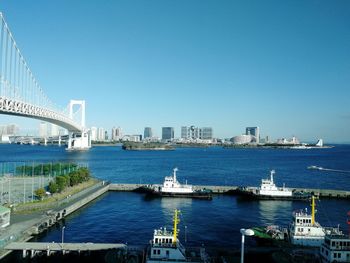 View of city at waterfront against blue sky
