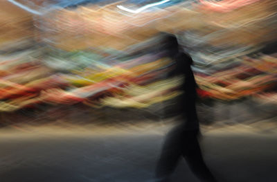 Blurred image of man walking on road