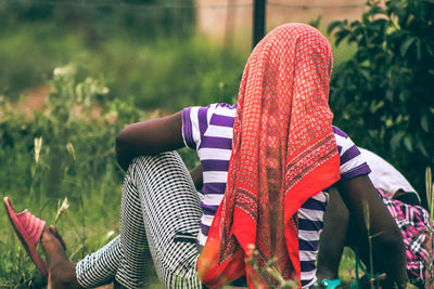 Rear view of woman with umbrella on plants