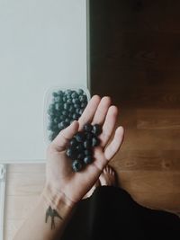 Cropped image of woman holding fruit on floor