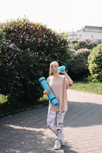 Full length of woman standing on footpath