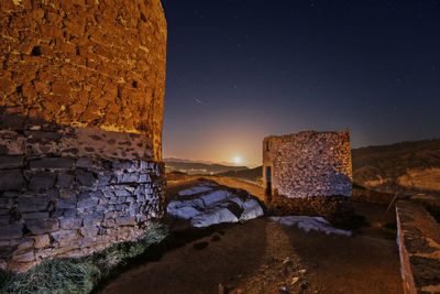 Stone wall against sky at night