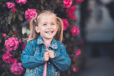 Happy girl standing near flowers