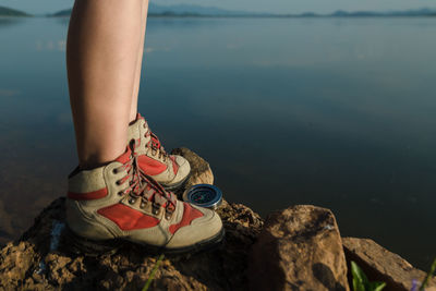 Low section of woman on rock by sea