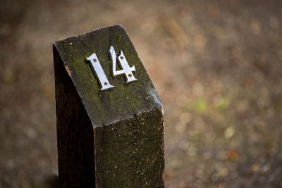 Close-up of sign on wooden post
