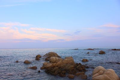 Rocks in sea against sky