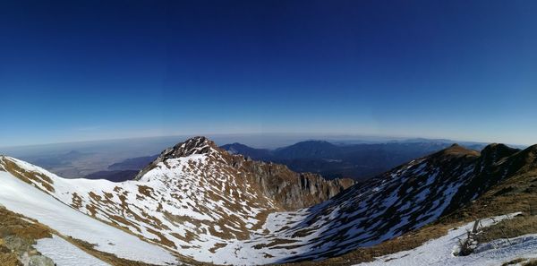 Scenic view of snowcapped mountains against clear blue sky