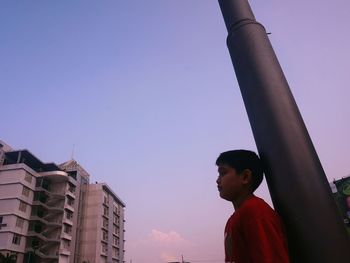 Low angle view of woman standing against built structure