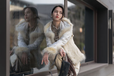 Portrait of young woman standing in city