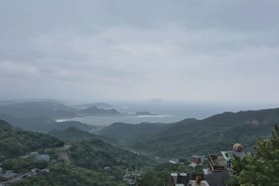 Scenic view of townscape and mountains against sky