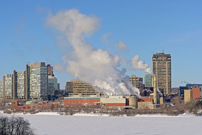 Buildings in city against sky during winter