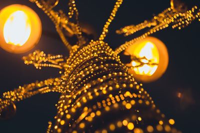 Low angle view of illuminated lighting equipment hanging on ceiling