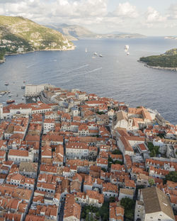 High angle view of townscape by sea against sky