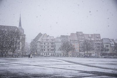 Snow covered city against sky