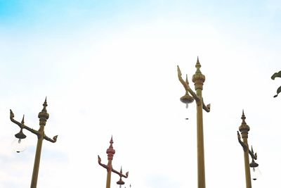 Low angle view of sculpture on street light against sky