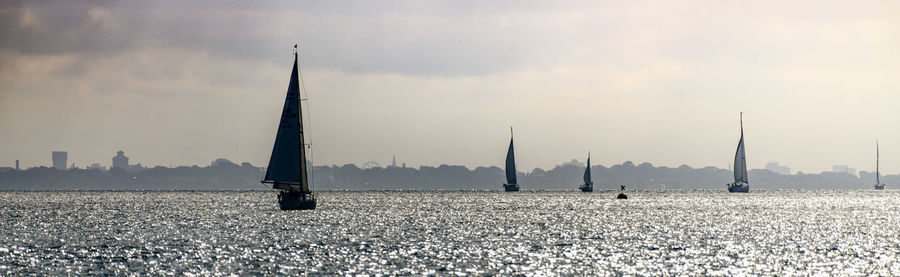 Sailboats on field against sky