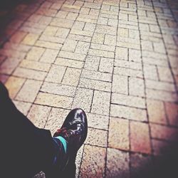 Low section of person standing on tiled floor