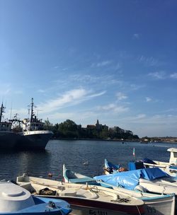 Boats moored at harbor against sky