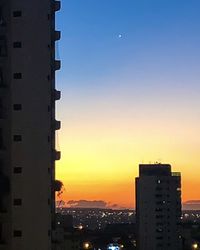 Silhouette buildings against sky during sunset