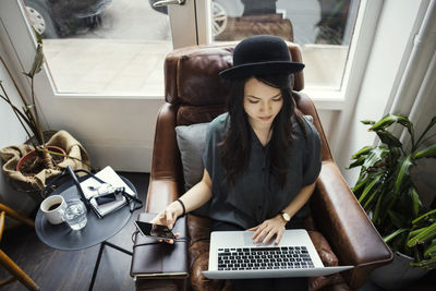 High angle view of creative businesswoman working while sitting on chair