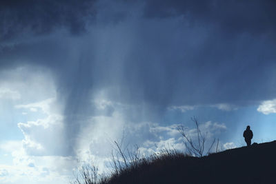 Low angle view of silhouette man standing against sky