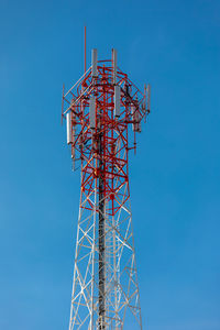 Low angle view of communications tower against blue sky