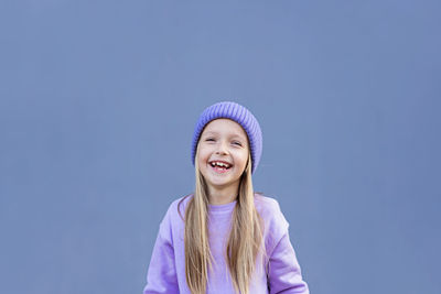 Portrait of cute girl against purple background