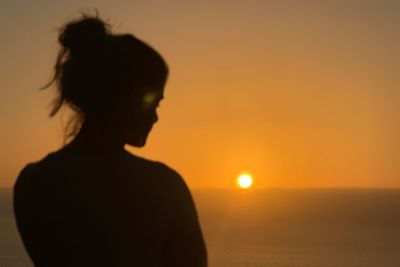 Rear view of silhouette man against sunset sky