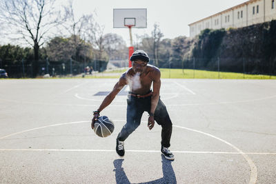 Barechested basketball player in action on court