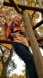 Low angle portrait of smiling girl on tree