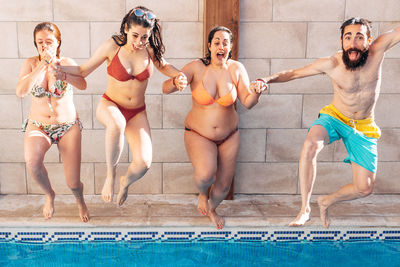 Full length of friends enjoying in swimming pool