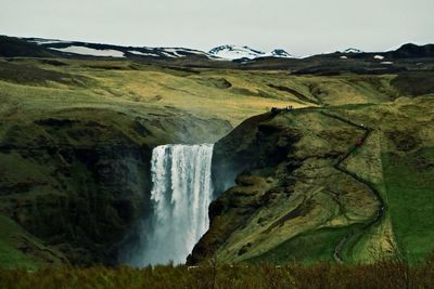 Scenic view of waterfall against sky