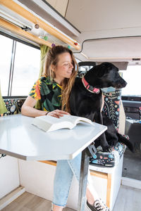 Woman traveling with dog in camper van