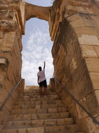 Rear view of man standing on staircase