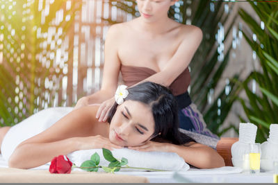 Midsection of woman relaxing on plant