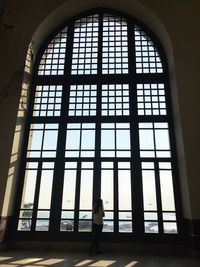 Silhouette woman standing by window in building