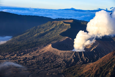 Smoke emitting from volcanic mountain against sky