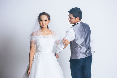 Young couple standing against clear sky